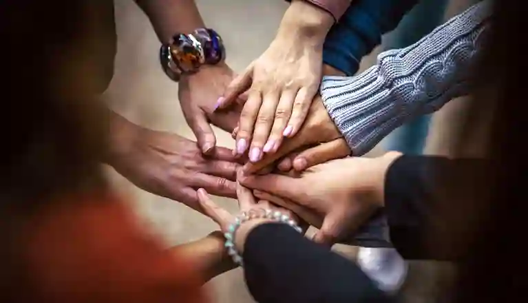 Bild som visar ett antal händer som möts och visar en känsla av gemenskap och samarbete.
