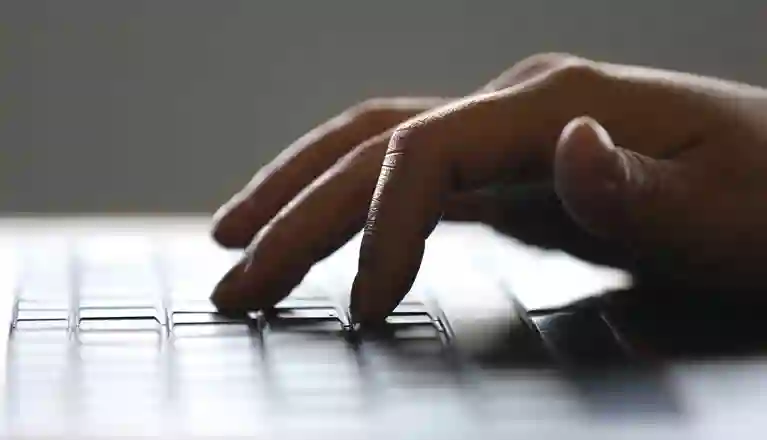 Bild på skrivande hand på tangentbord.