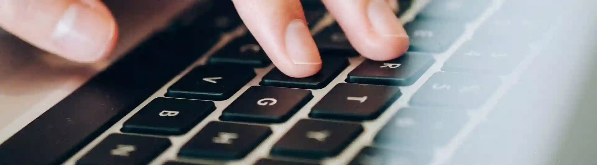 Bild som visar en hand på en bärbar dator.